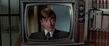 Movie still from “Escape from the Planet of the Apes” (1971), directed by Don Taylor – A person in a suit on a television screen; Close Up shot, Over the shoulder angle