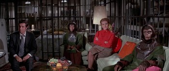 Movie still from “Escape from the Planet of the Apes” (1971), directed by Don Taylor – Two women sitting on a couch in front of a table; Wide shot, High angle