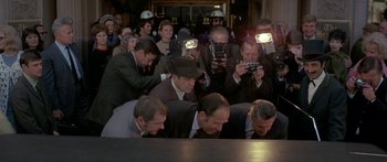Movie still from “Escape from the Planet of the Apes” (1971), directed by Don Taylor – A group of men sitting around a table with their heads down; Wide shot, High angle