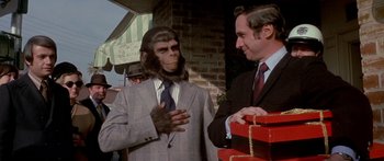 Movie still from “Escape from the Planet of the Apes” (1971), directed by Don Taylor – A man in a suit talking to a man in a suit and tie; Medium shot, Over the shoulder angle