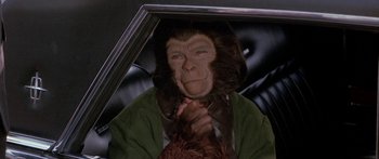 Movie still from “Escape from the Planet of the Apes” (1971), directed by Don Taylor – A person with a monkey mask in a car; Close Up shot, High angle