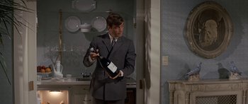 Movie still from “Escape from the Planet of the Apes” (1971), directed by Don Taylor – A man in a suit holding a bottle of wine; Medium shot, Low angle