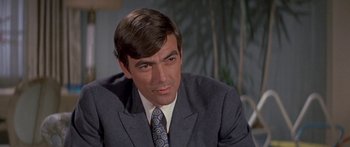 Movie still from “Escape from the Planet of the Apes” (1971), directed by Don Taylor – A person wearing a suit and tie; Close Up shot, Over the shoulder angle