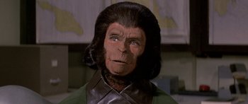 Movie still from “Escape from the Planet of the Apes” (1971), directed by Don Taylor – An image of a man dressed like a monkey; Close Up shot, Over the shoulder angle