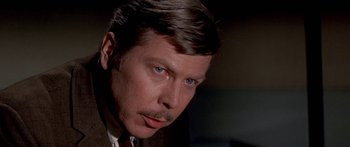 Movie still from “Escape from the Planet of the Apes” (1971), directed by Don Taylor – A person wearing a suit and tie; Close Up shot, Over the shoulder angle