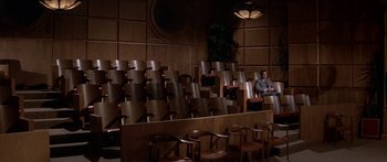 Movie still from “Escape from the Planet of the Apes” (1971), directed by Don Taylor – A man sitting in a courtroom with many empty chairs; Extreme Wide shot, High angle