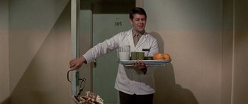 Movie still from “Escape from the Planet of the Apes” (1971), directed by Don Taylor – A man holding a tray of fruit and a glass of milk; Medium shot, Over the shoulder angle