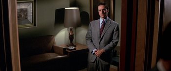 Movie still from “Escape from the Planet of the Apes” (1971), directed by Don Taylor – A man in a suit standing in front of a lamp; Medium shot, Low angle