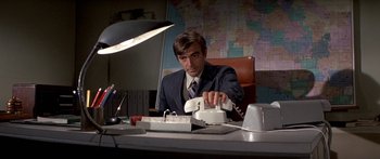 Movie still from “Escape from the Planet of the Apes” (1971), directed by Don Taylor – A man sitting at a desk in front of a map; Medium shot, Low angle