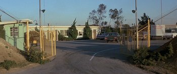 Movie still from “Escape from the Planet of the Apes” (1971), directed by Don Taylor – Cars parked in a parking lot next to a building; Extreme Wide shot, High angle