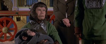 Movie still from “Escape from the Planet of the Apes” (1971), directed by Don Taylor – An old man dressed as a monkey holding a baby; Close Up shot, High angle