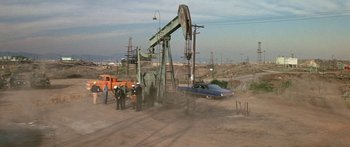 Movie still from “Escape from the Planet of the Apes” (1971), directed by Don Taylor – An oil well with a car on top of it; Extreme Wide shot, High angle