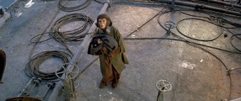 Movie still from “Escape from the Planet of the Apes” (1971), directed by Don Taylor – A monkey that is holding something in his hands; Wide shot, Overhead angle