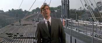 Movie still from “Escape from the Planet of the Apes” (1971), directed by Don Taylor – A man in a suit standing on a bridge; Close Up shot, Low angle