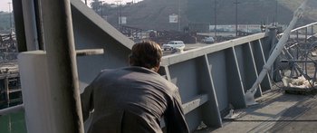 Movie still from “Escape from the Planet of the Apes” (1971), directed by Don Taylor – A man in a suit looking over a bridge; Wide shot, Over the shoulder angle