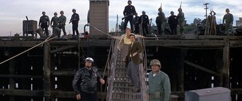 Movie still from “Escape from the Planet of the Apes” (1971), directed by Don Taylor – A group of men standing on top of a wooden deck; Wide shot, High angle