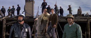 Movie still from “Escape from the Planet of the Apes” (1971), directed by Don Taylor – A group of men standing on top of a set of stairs; Wide shot, Low angle