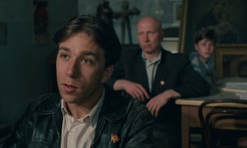 Movie still from “Europa Europa” (1990), directed by Agnieszka Holland – A man sitting next to another man in a room; Close Up shot, Over the shoulder angle