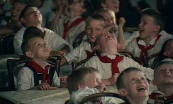 Movie still from “Europa Europa” (1990), directed by Agnieszka Holland – A group of children sitting in a room laughing; Medium shot, High angle