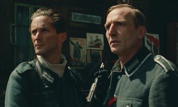 Movie still from “Europa Europa” (1990), directed by Agnieszka Holland – A couple of men standing next to each other holding guns; Close Up shot, Low angle