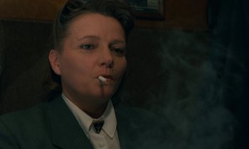 Movie still from “Europa Europa” (1990), directed by Agnieszka Holland – A woman smoking a cigarette while wearing a suit and tie; Close Up shot, Low angle