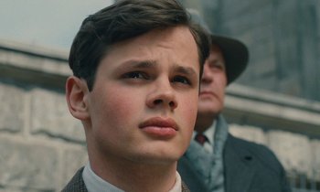 Movie still from “Europa Europa” (1990), directed by Agnieszka Holland – A young man in a suit and tie next to an older man in a hat; Close Up shot, Low angle