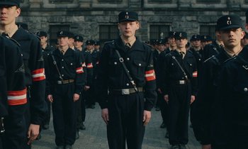 Movie still from “Europa Europa” (1990), directed by Agnieszka Holland – A group of men in uniform standing next to each other on a street; Medium shot, Low angle