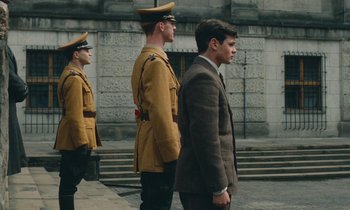Movie still from “Europa Europa” (1990), directed by Agnieszka Holland – A man in a brown suit and a man in a brown suit and a man in a brown suit and a man in a brown suit; Wide shot, Low angle