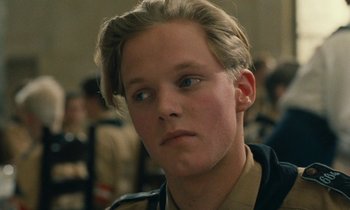 Movie still from “Europa Europa” (1990), directed by Agnieszka Holland – A young man with blonde hair wearing a military uniform; Close Up shot, High angle