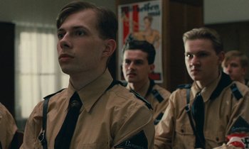 Movie still from “Europa Europa” (1990), directed by Agnieszka Holland – A group of young men standing next to each other in a room; Close Up shot, Low angle
