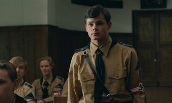 Movie still from “Europa Europa” (1990), directed by Agnieszka Holland – A man in a uniform stands next to another man in a uniform; Medium shot, Over the shoulder angle