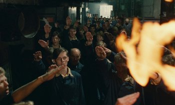 Movie still from “Europa Europa” (1990), directed by Agnieszka Holland – A group of people standing in front of a fire; Wide shot, High angle