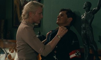 Movie still from “Europa Europa” (1990), directed by Agnieszka Holland – A woman adjusting the collar of a young man; Medium shot, Over the shoulder angle