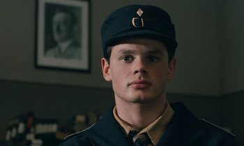 Movie still from “Europa Europa” (1990), directed by Agnieszka Holland – A young man in a military uniform wearing a hat; Close Up shot, Low angle