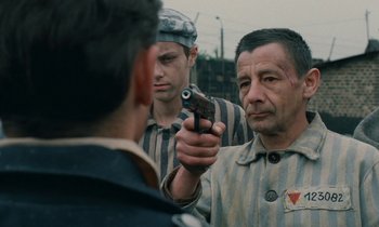 Movie still from “Europa Europa” (1990), directed by Agnieszka Holland – A man holding a gun pointed at another man; Medium shot, Over the shoulder angle