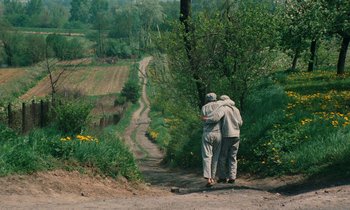 Movie still from “Europa Europa” (1990), directed by Agnieszka Holland – Two people standing on a dirt path near a forest; Wide shot, High angle