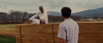 Movie still from “Evan Almighty” (2007), directed by Tom Shadyac – A man sitting on top of a wooden platform; Wide shot, Over the shoulder angle
