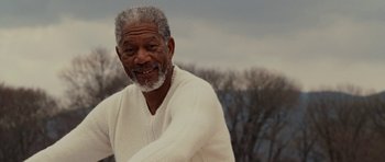 Movie still from “Evan Almighty” (2007), directed by Tom Shadyac – An older man in a white sweater smiling for the camera; Close Up shot, Low angle