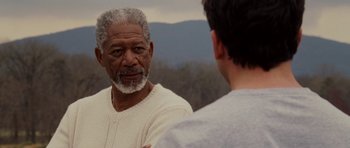 Movie still from “Evan Almighty” (2007), directed by Tom Shadyac – A man standing next to another man in front of a mountain range; Close Up shot, Over the shoulder angle