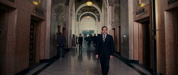 Movie still from “Evan Almighty” (2007), directed by Tom Shadyac – A man in a suit and tie walking down a hall way; Wide shot, Low angle
