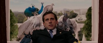 Movie still from “Evan Almighty” (2007), directed by Tom Shadyac – A man in a business suit surrounded by pigeons; Medium shot, Low angle