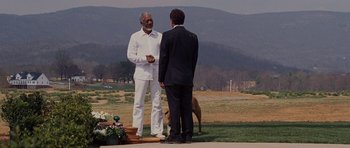 Movie still from “Evan Almighty” (2007), directed by Tom Shadyac – Two men in suits standing next to each other on a field; Wide shot, Over the shoulder angle