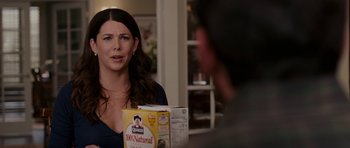 Movie still from “Evan Almighty” (2007), directed by Tom Shadyac – A woman in a blue shirt is holding a box of cereal; Close Up shot, Over the shoulder angle