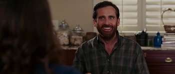 Movie still from “Evan Almighty” (2007), directed by Tom Shadyac – A man in a green and brown plaid shirt smiling; Close Up shot, Over the shoulder angle