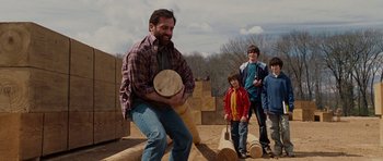 Movie still from “Evan Almighty” (2007), directed by Tom Shadyac – A group of kids and a man playing with a wooden drum; Medium shot, Over the shoulder angle