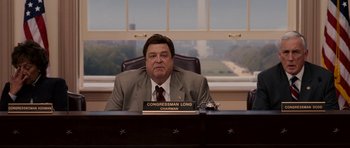 Movie still from “Evan Almighty” (2007), directed by Tom Shadyac – A person sitting at a desk in front of a window; Medium shot, Low angle