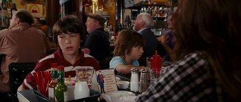 A group of people sitting at a table in a restaurant