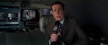 Movie still from “Evan Almighty” (2007), directed by Tom Shadyac – A man wearing a suit and tie holding a microphone; Close Up shot, Over the shoulder angle