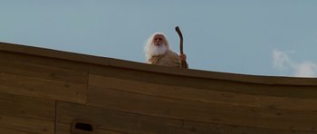 Movie still from “Evan Almighty” (2007), directed by Tom Shadyac – An old man with a white beard holding a wooden stick; Wide shot, Low angle