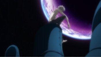 Movie still from “Evangelion: 2.0 You Can (Not) Advance” (2009), directed by Joe Fria – A man sitting on top of a rock in front of a planet; Extreme Wide shot, Low angle